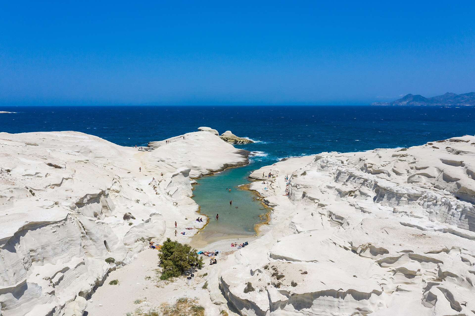 Cena de reportagem: file:Sarakiniko Beach on Milos Island, Greece with a view of the Aegean Sea.jpg, no trecho “Por que Milos parece lunar”