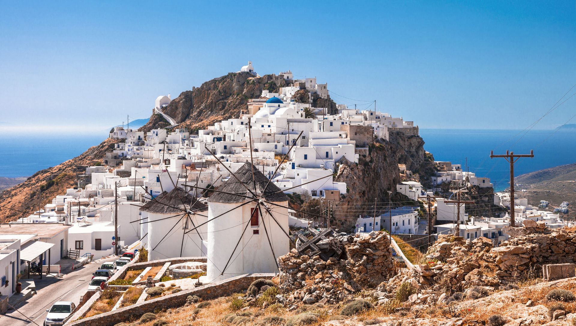 Cena de reportagem: pamela Goodman: Don't mess with the wind, else it might just blow your car doors, no trecho “As mais conhecidas: Mykonos, Santorini e Milos”
